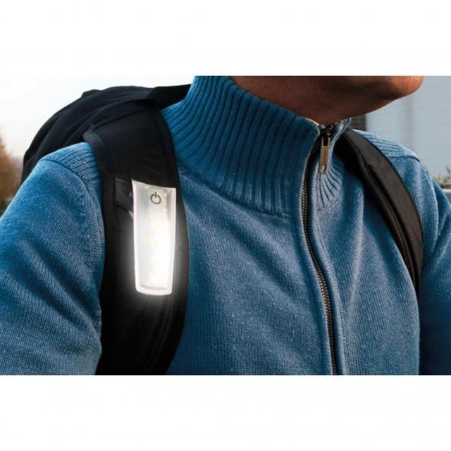 LED clip-on safety light worn on backpack strap for nighttime visibility