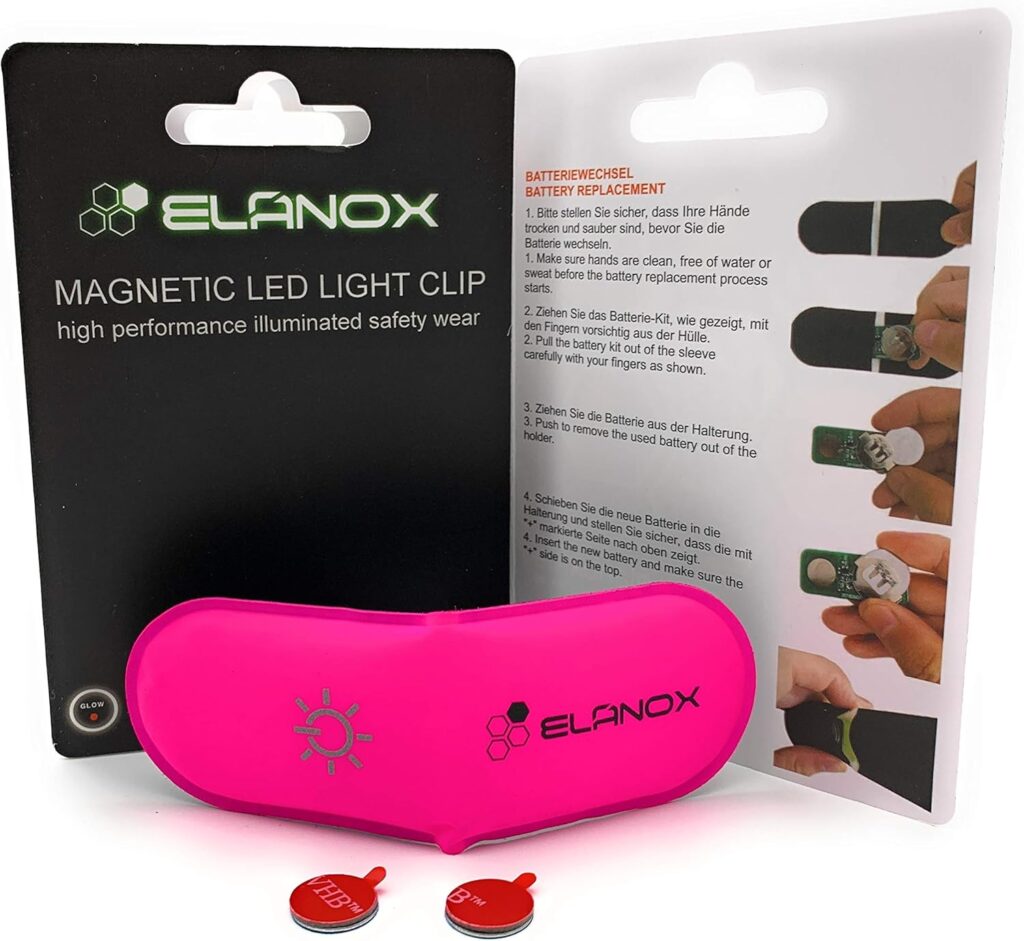 Magnetic LED safety light clip shown with retail blister packaging, including battery replacement instructions and spare button batteries, suitable for high-visibility safety use